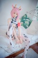 A woman in a cow costume sitting on a bed.